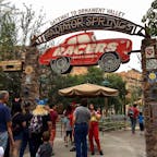アナハイム(カリフォルニア)

ラジエーター・スプリングス・レーサー(Radiator Springs Racers)のエントランス。

ディズニー・カリフォルニア・アドベンチャー・パーク(Disney California Adventure Park)にて。

映画「カーズ」シリーズとルート66にインスピレーションを受けて作られたカーズランド。他2つのアトラクションや、フローのV8カフェ(Flo’s V8 Cafe)などのレストランやお店が、ラジエーター・スプリングスを再現した世界に広がっている。メイン・ストリートはルート66がモチーフ。

6人乗りのレース・カーに身を沈めたら、カラフルな岩肌やキャデラック・レンジの南西部風景、流れ落ちる滝を見ながら、オーナメント・バレーを軽くドライブ。

カーマニアなら、6つの山々の頂が、1957年〜1962年モデルのクラッシックなキャデラックの、テール部分に似ていることに気づくのでは。

この山並は、ルート66沿いのテキサス州アマリーリョの街にある、キャデラック・ランチのパブリック・アート(ペイントされたキャデラックが10台、地面に突き刺さった状態で並んでいる)が元になっているそう。

やがてラジエーター・スプリングスの夜の街に到着すると、レースに向けてマックィーンやサリー、メーターなど全員がお出迎えしてくれ、カーズの世界が目の前に。

いよいよ車のチューンナップのため、ルイージのタイヤのお店、もしくはラモーンのボディペイントのお店へ。どちらに行くかは自分では決められないので、その時次第。

調整を済ませてお店を抜けると、対戦相手と横並びに。一呼吸おいて、スタート。2台が常に競り合いながら、後は一気にフィニッシュ・ラインまで高速で駆け抜ける。

アップダウンがあったり、軽いコーナリングで体が傾いたり、ふわっとお腹がすくような感覚は受けるけれど、走りもとてもスムーズで、ジェットコースター系が苦手でも乗れる程度のほどよいスリルが味わえる。

午前と午後で1回ずつ搭乗し、もうあと2〜3回乗りたかったと思うほど楽しかった、ここだけのアトラクション。昼と夜では雰囲気や迫力も違うので、時間帯を変えて乗るのもお勧め。

#carsland #california #adventurepark #anaheim