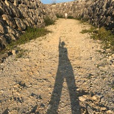 南大東  夕日の広場。
180度一直線の海岸線に沈む夕日はきれいでした。という写真も良いけれど、日が低いことがよくわかる足の長さ！