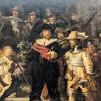 🇳🇱  オランダ・アムステルダム国立美術館

『夜警』

美術史上でも偉大な画家と言われれているレンブラント・ファン・レイン（1606年〜1669年）の代表作。

アムステルダムの市民警備隊のホール、クロフェニアス・ドーレンに飾るために描かれたものでしたが、1715年、市警団の全盛期が過ぎて、アムステルダム市は絵画をクロフェニアス・ドーレンからアムステルダム市庁舎（現在の王宮）に移すことになりました。
しかし絵が大きすぎ、市庁舎の絵を飾る場所に収まりきらないため、今では信じられませんが、一部が切り取られてしまったとのことです🤯

それが分かる資料として、ヘリット・ランデンスが描いたとされている『夜警』の複製品があります。（3枚目）
ロンドンにあるナショナル・ギャラリー所蔵作品ですが、2018年〜2023年の間アムステルダム国立美術館に貸し出しされていて、オリジナル作品のそばに展示されており、今回運良く見ることができました😊
この絵と比較すると、左側、上部、右側が切り取られているのがわかります。

それでもこの絵画の大きさは縦363cm、横は437cmもあり、アムステルダム国立美術館の広いホールの突き当たりに飾られているのが、正面入り口からも見ることができます。
（4枚目=対面にあるステンドグラスが反射していますが…😅）

2019年7月から過去最大規模の調査・修復プロジェクトが開始され、館内で今現在も行われています。
ガラス壁の向こうにキャンバスは掛けられており、作業の過程を美術館でも、オンライン上でも見られるようになっています。
（6、7枚目）


#puku2'23
#puku2"10
#puku2ベネルクスへの旅🇳🇱
#puku2美術館
#アムステルダム国立美術館#レンブラント#夜警
