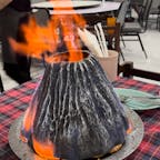ナコンパトムの火山エビ
クンオッププーカオファイ

バンコクから車で西に1時間ほど
ナコンパトムにあるタイ料理屋さん
この店で1番有名な料理が火山エビ
山の形をしたカバーの上から燃える油をかけて着火
映えまくるエビ料理です。

鎮火したのち、店員さんにお願いすれば、海老の殻を綺麗に剥いてもらえます。

ナムチム(調味料)に付けて食べたら超美味しいです。

タイ料理も色々あり、トムヤムクン、エビチャーハン、ゲーンソム(辛いスープ)、プラーチョン(雷魚)の料理やタイの冷たいデザート、果物のスムージーなど甘いもののメニューも充実していて、とりあえずここに来ればタイ料理はバッチリです。
冷房の効いた室内席もあるので、ゆっくり快適にご飯が食べられます。