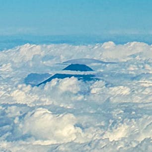 頭を雲の上に出した富士山