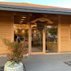 奈良県桜井市 今西酒造 三輪伝承蔵
大神神社の参道にできた、今西酒造さんの新しい酒蔵です。吉野杉が使われた建物内に入ると、ガラス越しに木桶が見られます。
こちらで造られたお酒、お土産を買い求められるほか、カウンターで気軽にお酒を味わうことができます。一杯90mlで、酒米、精米歩合から選べます。